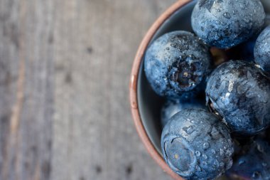 Yarım kâse, ıslak, koyu yaban mersinli, koyu ahşap, yatay, fotokopi alanı olan.