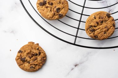 Siyah ızgara üzerinde çikolatalı kurabiyelerin havadan görünüşü, beyaz mermer masa üzerinde, seçici odak, yatay, kopyalama alanı olan