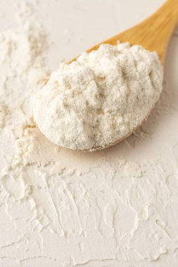 Tahta kaşığın üst görüntüsü beyaz ahşap masa üzerinde, dikey, kopyalama alanı ile