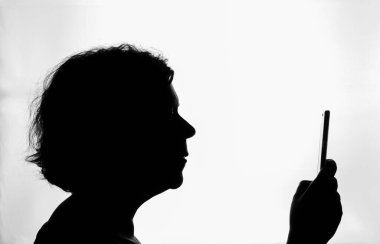 Profilde siyah siluet, akıllı telefonuna danışan bir kadın, beyaz arka planda, yatay olarak, kopyalama alanı ile