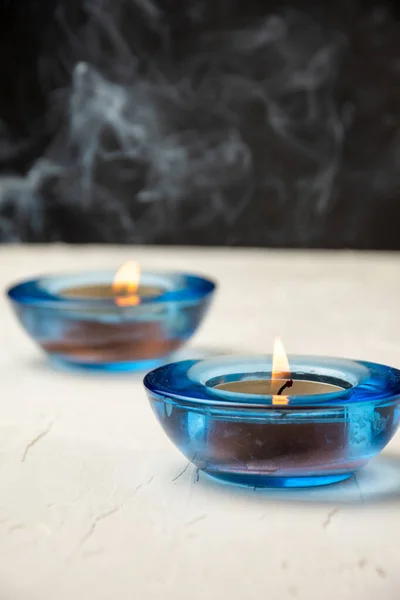 View Two Burning Candles Blue Glass White Table Incense Smoke — Stock Photo, Image