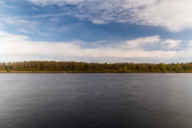 Gölde bir yaz günü, gölün karşı tarafında bir orman, uzun süreli su. Manzara.