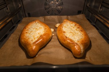 Fırında iki khachapuri pişiyor. Yumurtalı kabuk, yakın plan..