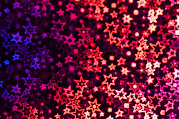 Multicolored stars shimmer in different shades, starry bokeh, background. Abstraction.