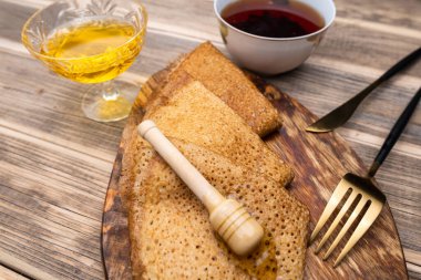 Ballı krep ve ahşap tepside çay. Altın bıçak ve çatal. Yakın plan..