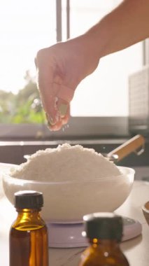 Dikey video. Güneş Işıklı Mutfak Yavaş Hareketi 'nde Soya Cila Fışkırtan Kadın, Ev Yapımı Mum Yapımı Hobi Konsepti