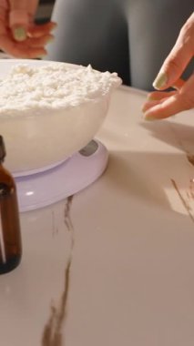 Dikey video. Kadının Yakın Çekimi Soya Culası Gevreğini Gümüş Tencereye Koyuyor Elleri Yavaş Görünür Hareket, Mum El Yapımı Hobisi