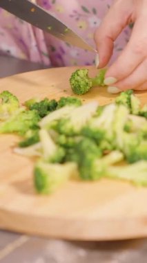 Dikey video. Mutfaktaki Ahşap Tahta Tahtadaki Çoklu Brokoli Parçalarını Kesen Yavaş Hareket Çerçevesinde Lavabo ve Önlük