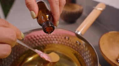 Temel Yağ 'ın Macro Kapanışı Kahverengi Şişe' den Altın Balmumu 'na Damlayan Pembe Spatula Görünürde, Doğal Sanatsal Sanatta