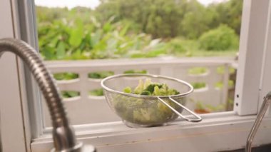 Colander Buharlı Brokoli ile Dolu Açık Pencere Ledge with Lush Garden in Background, Geniş Açı, Doğal Gün Işığı, Sağlıklı Aşçılık Konsepti