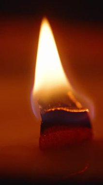 Dikey video. Ahşap Wick Alevi 'nin Macro Kapanışı Keskin Odaklı Kömürlü Kenar Mum Yavaşça Dönerken Sıcak Tonlar ve Yumuşak Yansıma Yavaş Çekim, Aromaterapi Konsepti