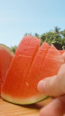 Dikey video. El Tutma Taze Kesme Karpuz Kesme Tahta Yüzey üzerinde Bıçak ve Açık Hava Sahnesi, Taze Meyve Kavramı