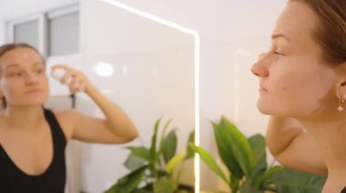 Tuvalet aynası, kenar açı, Güzellik ve Kendine Bakım Konsepti 'nde Cilt Bakımı Rutininden Önce Kadın Sprey Suratı