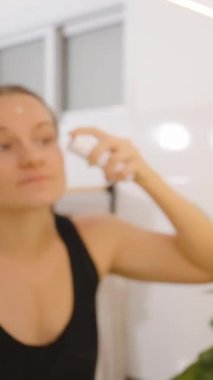 Dikey video. Tuvalet aynası, kenar açı, Güzellik ve Kendine Bakım Konsepti 'nde Cilt Bakımı Rutininden Önce Kadın Sprey Suratı