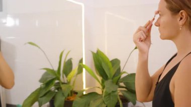 Kadın Alnına Parlak Banyo 'da Yeşim Roller ile Masaj Yapan Kadın, Yan açı, Yaşlanma Karşıtı Kavram