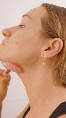 Dikey video. Çene Masaj Kadın Pembe Yeşim Roller Banyo, yakın açı, Cilt Kavramı