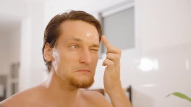 Banyodaki aynada alnına krem süren adam, yakın görüş, sağIık kavramı