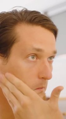 Dikey video. Göz Altında Masaj Yapan Adam Banyoda Parmağı Var, Yakın açı, Yaşlanma Karşıtı Kavram