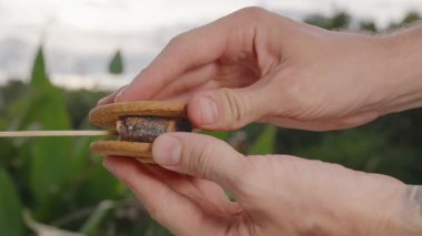 Erimiş Marshmallow Doldurmalı El Tutma Bitmiş Bisküvi Sandviçi Açık Sahne, Yavaş Çekim, Smore Tatlı Konsepti