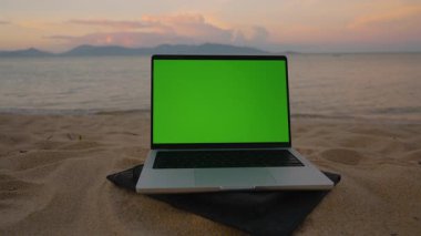 Sunset Wide Shot, Uzaktan Ofis ve Serbest Yaşam Tarzı Konsepti 'nde Kum Denizi' ne bakan Yeşil Ekranlı Dizüstü bilgisayar