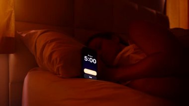 Sabahın 5 'inde yataktaki kadın Smartphone Alarmını Durdurmak İçin Ulaşır Sonra Parlak Pencereden Bakar ve Sabah Sabah Gevşemesini Kapar