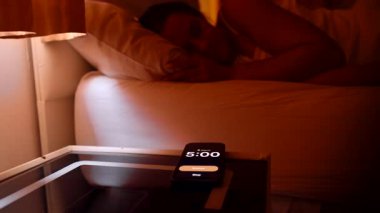 Akıllı telefondan sabah 5 'ten sabah 5' e kadar uzanan kadın. Sonra parlak bir sabahta pencereden dışarı bakan ve uykulu bir sabah rutini.