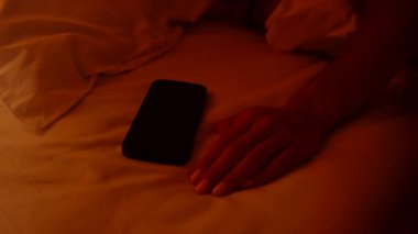 Nazikçe Dokunan Akıllı Telefon Alarmı Sabah 6 'yı gösteriyor Yumuşak Turuncu Sabah Tembelliğinde Yatakta Yatarken