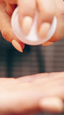 Vertical video. Woman Squeezing White Shaving Foam from Bottle into Palm with Close-Up on Hands and Smooth Nails, Shallow Depth of Field, Shaving Preparation Concept