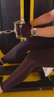 Dikey video. Spor Salonundaki Kablo Makinesinde Elleri Tutma Sırasının Kapanışı, Eldiven Giyme ve İzleme, Güç Çalışmasının Detayları