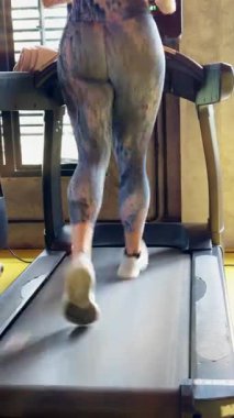 Dikey video. Spor Bacaklı Spor Değirmeni 'nde Doğal Işık Yansımaları, Zindelik ve Motivasyon Konsepti ile Arka Bakış Atletik Kadın Egzersizi