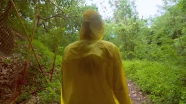 Sarı Yağmurluklu Kadın Karanlık Tünelden Parlak Yeşil Ormana Yürüyor Yeniden Doğuş ve Özgürlük Konseptini sembolize ediyor