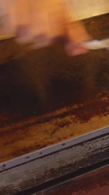 Metal Griddle with Melted Butter Being Spread by Spatula, Captured from Side Angle, Street Cooking Concept