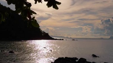 Green Peninsula Silhouette and Shimmering Water under Soft Sunlight, Captured from Side Angle, Tropical Tranquility Concept