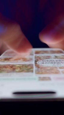 Dikey video. Parlak Akıllı Telefon Görünümünde Eller Hızlı Kaydır Kırmızı ve Mavi Işık Karşıtlığında Shutter Sürükleme Bulanıklığı ile Tüm Yaşamı Işıklandıran Akıllı Telefon ve Dijital Aşırı Yükleme