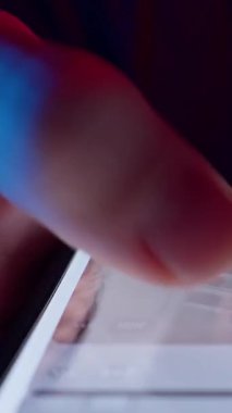 Dikey video. Man Hızlı Kaydırma Sosyal Medya Beslemesi Akıllı Telefon Ekranında Hızlı Dolly Kaydırma Hareketi ve Neon Işığı ile Tüm Yaşamı Gösteren Akıllı Telefon 'da