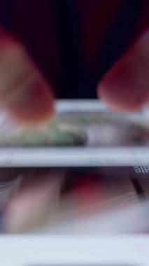 Dikey video. Adam Akıllı Telefon Ekranında İki Parmakla İçerik Kaydırırken Kamera Kırmızı ve Mavi Işık Altında Geriye Kayıyor Tüm Yaşamı Vurguluyor Akıllı Telefon ve Duygusal Mesafe