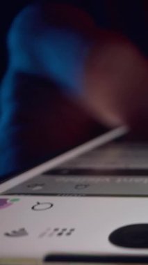 Dikey video. Hızlı Dolly Kaydırma Kamerası Hareketi sırasında Haberler İçinden İki Parmak Kayıyor Kırmızı ve Mavi Işık Tüm Yaşamı Gösteriyor Smartphone 'da