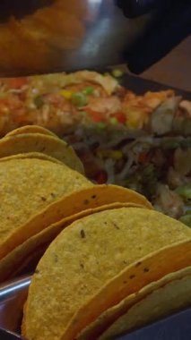 Dikey video. Taze sert kabuklu takolar Tavuk, lahana ve sebzelerle dolu Izgara İstasyonunda, Meksika sokak yiyeceklerine hazırlık konsepti