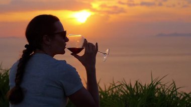 Mat 'in üzerinde otururken Şarap İçen Kadın Okyanus, Geniş Açı, Huzur Yalnızlığı Konsepti Üzerinde Gün Batımını İzliyor