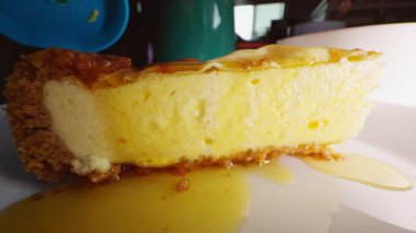 Beyaz tabakta karamel soslu dilimlenmiş cheesecake, yakın plan, tatlı tatlı tatlı konsepti