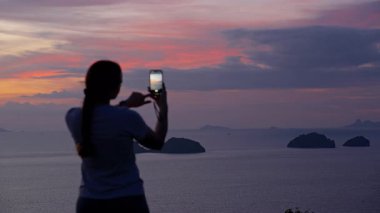 Hilltop, Rear View, Peaceful Technology Concept 'dan Smartphone ile Kadın Fotoğraflama Adası Günbatımı