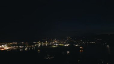 Şehir 'in Gece Havadan Görünümü Nehir Üzerine Trafik Işıkları ve Yansımaları, Şehir Sokakları ve Aydınlanmış Binalar, Gece Yaşamı ve Hareket Konsepti Zaman Alanı