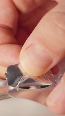 Dikey video. Yumuşak Odaklanma ve İlaç Konsepti ile Kapsüle Yakın Bakış Açı Görünümünde Erişmek için Kabarcık Paketinden Folyo Çıkarılıyor