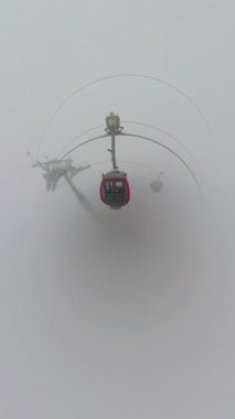 Dikey video. Geniş Açı Hava Görünümü 'nde Ba Na Tepeleri' ndeki Çoklu Kulübelerle Kalın Sis Aracından Yaklaşan Kırmızı Kablo Arabası