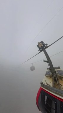 Dikey video. Geniş Açı Hava Yakalamada görülen Ba Na Tepeleri 'ndeki Yoğun Sis' in Üzerinde Yürüyen Kablo Araba
