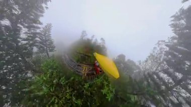 Sarı Füniküler Araba, Ba Na Hills 'teki Puslu Orman' da Kıvrımlı Pist boyunca Dönüyor. Geniş Açı 'da Küçük Gezegen Efektiyle Görülüyor.