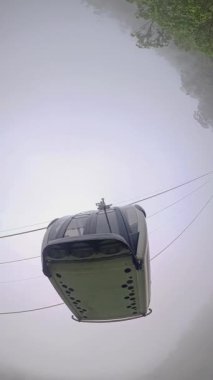 Dikey video. Ba Na Hills 'te Dağ Yamaçları Görünümlü Dramatik Delik Gezegeni Efekti' nde Araba Askıya Alındı