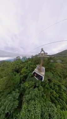 Dikey video. Geniş Açı Hava Perspektifinde Dramatik Derinlikte Sisten Çıkan Kablolu Araba Dağ Ormanının Üzerinden Geçiyor