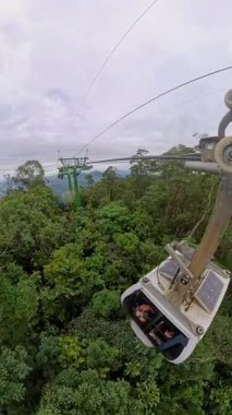 Dikey video. Yoğun Yeşil Orman 'ın yukarısındaki Uzun Destek Kulesi' ne yakın Kablo Arabası Geniş Açı Hava Görünümünde Güçlü Derinlikte Yakalandı