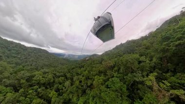 Lush Forest Hills 'in üzerinde süzülen kablo araba içinde görülebilen yolcularla birlikte yumuşak atmosferik sisle geniş açılı hava perspektifinde yakalandı.
